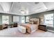 Spacious main bedroom with tray ceiling, carpet, three windows and stylish furniture at 111 Summerhill Dr # 2, Mooresville, NC 28115