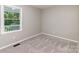 A well-lit bedroom features neutral walls and plush carpeting at 1118 Brookwood Dr, Stanley, NC 28164