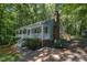 Charming home with front porch, brick chimney, and mature landscaping, surrounded by lush greenery and trees at 1118 Brookwood Dr, Stanley, NC 28164