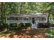 Charming home with a welcoming front porch, lush landscaping, and inviting curb appeal amidst a leafy surrounding at 1118 Brookwood Dr, Stanley, NC 28164
