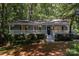 Charming home with a welcoming front porch, lush landscaping, and inviting curb appeal amidst a leafy surrounding at 1118 Brookwood Dr, Stanley, NC 28164