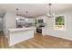 Open kitchen with white cabinetry, stainless appliances, an island with stone countertop and views of front porch at 1118 Brookwood Dr, Stanley, NC 28164