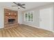 Inviting living room boasts a brick fireplace, wood floors, and a large window offering natural light and scenic views at 1118 Brookwood Dr, Stanley, NC 28164