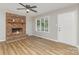 Inviting living room boasts a brick fireplace, wood floors, and a large window offering natural light and scenic views at 1118 Brookwood Dr, Stanley, NC 28164