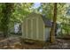 Image of the storage shed with double doors in a lush, wooded backyard at 1118 Brookwood Dr, Stanley, NC 28164
