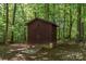 Exterior view of a wooded lot with a rustic storage shed at 1118 Brookwood Dr, Stanley, NC 28164