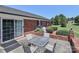 Backyard patio with a table and chairs, sliding glass door, and lush greenery at 116 Deer Trail Rd, Statesville, NC 28677