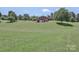 Spacious backyard, surrounded by mature trees, slopes up to the house at 116 Deer Trail Rd, Statesville, NC 28677