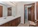 Functional bathroom featuring double sinks, wood cabinets, and a doorway to the shower area at 116 Deer Trail Rd, Statesville, NC 28677