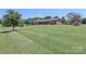 Expansive front lawn leads to a brick ranch-style home with a neatly manicured landscape at 116 Deer Trail Rd, Statesville, NC 28677