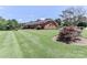 Well-maintained brick home with a lush, green lawn and mature trees on a sunny day at 116 Deer Trail Rd, Statesville, NC 28677