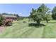 Well-manicured front lawn with mature trees, leading up to a charming brick home at 116 Deer Trail Rd, Statesville, NC 28677