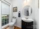 Charming powder room features modern vanity, toilet, window and decorative nautical theme at 11624 Crossroads Pl, Concord, NC 28025