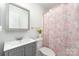 Clean bathroom featuring gray vanity, decorative flowers, and peach patterned shower curtain at 11624 Crossroads Pl, Concord, NC 28025