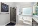 Bright bathroom featuring a large tub and a separate tiled shower with gray tiling at 11624 Crossroads Pl, Concord, NC 28025