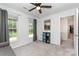 Cozy bedroom with a ceiling fan and large windows, with neutral-colored walls and gray carpet at 11624 Crossroads Pl, Concord, NC 28025