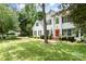 Beautiful two-story home with lush lawn, red front door, and surrounded by mature trees at 11624 Crossroads Pl, Concord, NC 28025