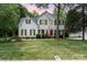 Charming two-story home with a well-manicured lawn, classic black shutters, and a vibrant red front door at 11624 Crossroads Pl, Concord, NC 28025