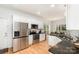 Bright kitchen boasts stainless steel appliances, granite counters, and light wood floors at 11624 Crossroads Pl, Concord, NC 28025