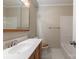 Bathroom features a white sink, toilet, and shower with a wooden vanity and towel rack at 1280 Queensgate St, Gastonia, NC 28054