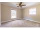 Bedroom features a ceiling fan, neutral carpeting, and natural light from two windows at 1280 Queensgate St, Gastonia, NC 28054