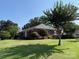 Beautifully landscaped yard surrounds this brick home with mature trees and lush green lawn at 1280 Queensgate St, Gastonia, NC 28054