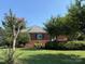 Brick home with a manicured lawn and mature landscaping, offering a serene setting at 1280 Queensgate St, Gastonia, NC 28054