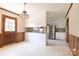Eat-in kitchen features stainless appliances, white cabinets, and access to wood paneled den at 1280 Queensgate St, Gastonia, NC 28054