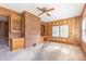 Living room with brick accent wall, built-in shelving, wood paneling, and a ceiling fan at 1280 Queensgate St, Gastonia, NC 28054