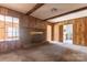 Living room with brick fireplace, wood paneled walls and an exposed doorway to the kitchen at 1280 Queensgate St, Gastonia, NC 28054