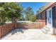 Brick patio area of the house with a low brick wall and lush green tree at 1280 Queensgate St, Gastonia, NC 28054
