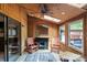 Cozy sunroom with wood paneled walls and ceiling, fireplace, skylight, ceiling fan, and rocking chairs at 1420 11Th Street Nw Dr # 15, Hickory, NC 28601
