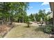 Spacious backyard with mature trees, a cozy patio area, and plenty of room for outdoor activities at 16402 Doves Canyon Ln, Charlotte, NC 28278