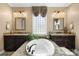Luxurious bathroom featuring separate vanities, a garden tub, and ample natural light at 16402 Doves Canyon Ln, Charlotte, NC 28278