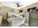 Well-lit bedroom with floral bedding, ample closet space, and a decorative ceiling fan at 16402 Doves Canyon Ln, Charlotte, NC 28278