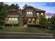 Charming stone home featuring a well-manicured lawn and professional landscaping at 16402 Doves Canyon Ln, Charlotte, NC 28278