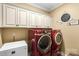 Modern laundry room with front-load washer/dryer and ample cabinet space for storage at 16402 Doves Canyon Ln, Charlotte, NC 28278