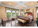 Lovely main bedroom with tray ceiling, hardwood flooring, bench, large windows, and natural light at 16402 Doves Canyon Ln, Charlotte, NC 28278