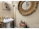 Charming powder room with pedestal sink, decorative mirror, and whimsical zebra artwork at 16402 Doves Canyon Ln, Charlotte, NC 28278