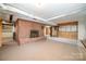 Unfinished basement with a brick fireplace, a wood-paneled bar, and carpet flooring at 165 Fieldstone Farm Dr, Statesville, NC 28625