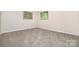 A neutral-colored bedroom with carpet flooring, two windows, and a closet at 165 Fieldstone Farm Dr, Statesville, NC 28625