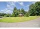 Quaint brick home with a well-manicured lawn and mature trees at 165 Fieldstone Farm Dr, Statesville, NC 28625