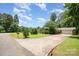 Ranch-style home featuring a well-manicured lawn, mature trees, and a large driveway leading to an attached garage at 165 Fieldstone Farm Dr, Statesville, NC 28625