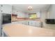 Well-lit kitchen featuring white cabinets, neutral countertops and flooring, and ample counter space at 165 Fieldstone Farm Dr, Statesville, NC 28625