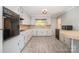 A bright kitchen with white cabinets, plank flooring, and contrasting black appliances at 165 Fieldstone Farm Dr, Statesville, NC 28625