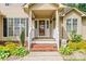 Close-up of the welcoming front porch with decorative plants and a cheerful 'hello' wreath at 1701 Whitney Ln, Salisbury, NC 28146