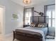 Well-lit bedroom with a dark wooden bed frame, unique decor, and window with shutter blinds for a relaxing ambiance at 2008 Thatcher Way, Fort Mill, SC 29715