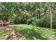 A lush backyard with a stone firepit and mature trees offers a serene outdoor retreat at 2012 Killarney Pl, Charlotte, NC 28262