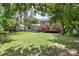 A well-maintained backyard with a deck, mature trees, and a manicured lawn surrounds the house at 2012 Killarney Pl, Charlotte, NC 28262