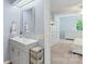 Ensuite bathroom with a gray vanity cabinet, storage baskets, and a view into the bedroom at 2012 Killarney Pl, Charlotte, NC 28262